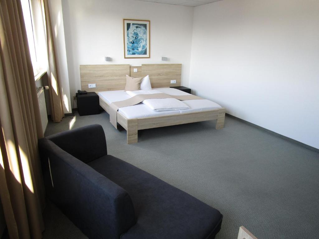 斯图加特斯图加特-维辛根商务酒店及公寓的一间卧室配有一张床和一张沙发