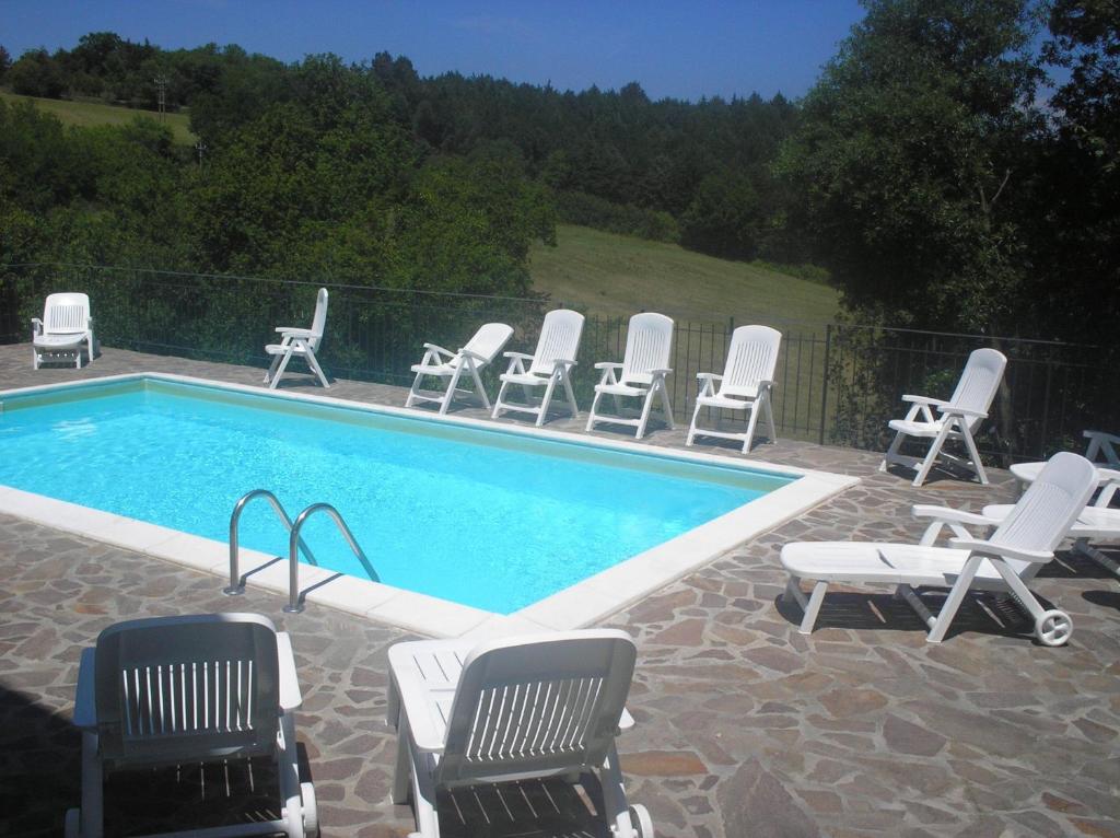 基乌斯迪诺Casa vacanza montecapino的一组椅子和一个游泳池