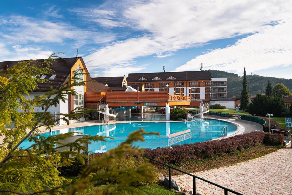 兹雷切温泉兹热西 - 活力酒店的大楼前设有大型游泳池的酒店