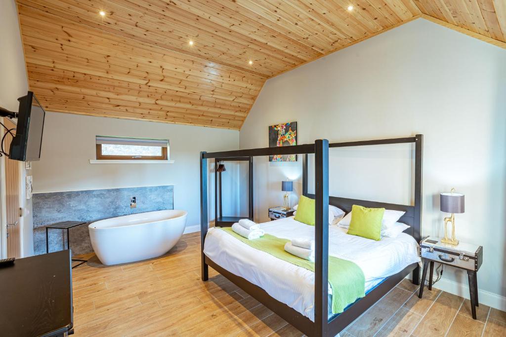 牛顿斯图尔特Kestrel Lodge 7 with Hot Tub的一间带浴缸、床和浴室的卧室
