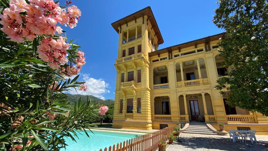 巴尔加莫琳格丝别墅酒店的一座黄色的大建筑,前面设有一个游泳池