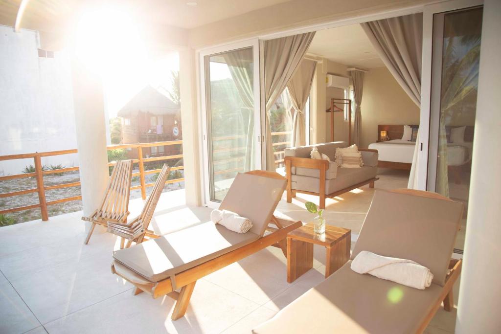 玛哈威Noah Beach Hotel & Suites的客厅配有两把椅子和一张沙发