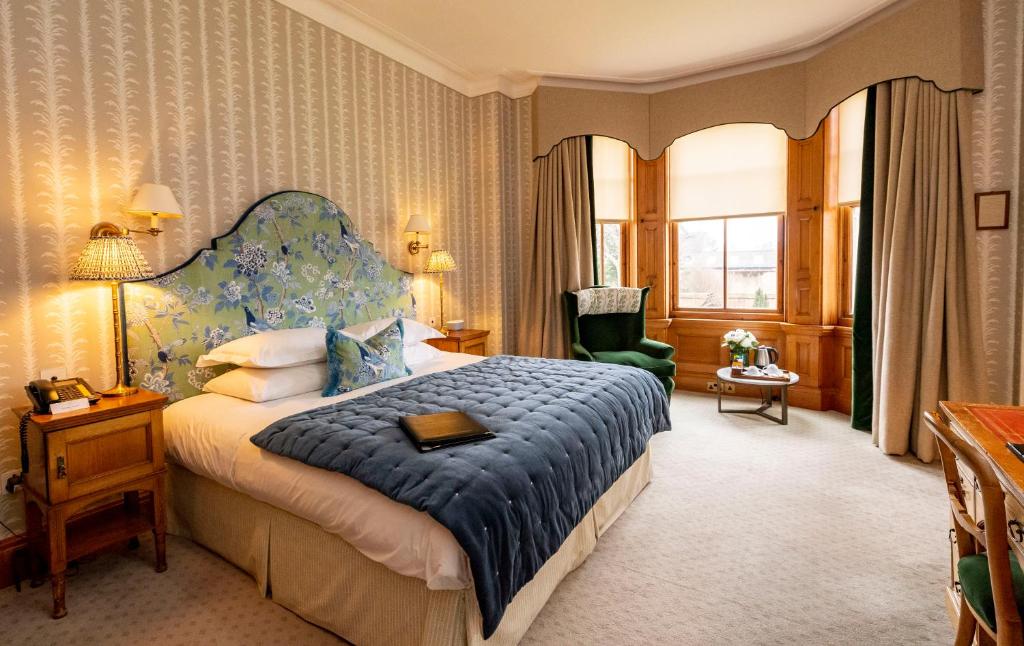 纽马基特The Jockey Club Rooms的一间卧室配有一张大床和蓝色床头板