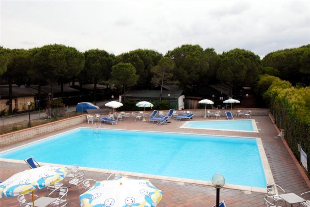 毕博纳的码头Parco Vacanze La Rosa dei Venti的一个带遮阳伞和椅子的大型游泳池
