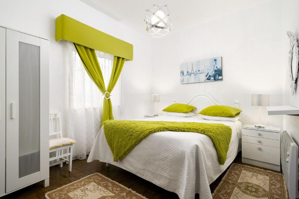 奥德赛克斯Casa Morais的一间卧室配有一张带绿色床单的床和一扇窗户。