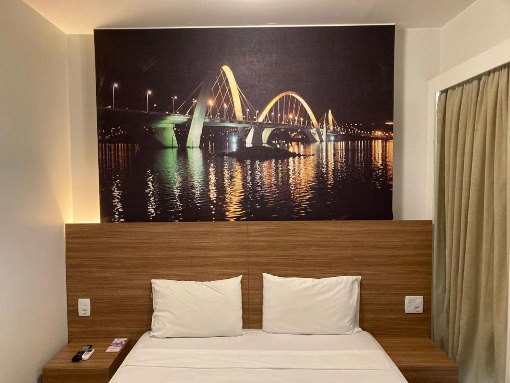 巴西利亚S4 HOTEL Águas Claras Flat的一间卧室,配有一张带桥景的床