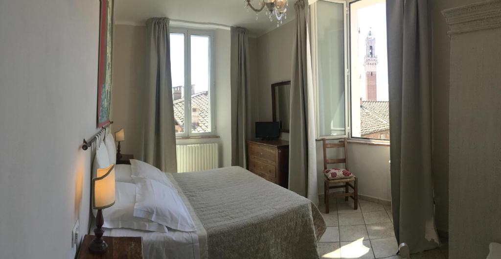 锡耶纳I Terzi Di Siena - Rooms Only的一间卧室设有一张床和两个窗户。