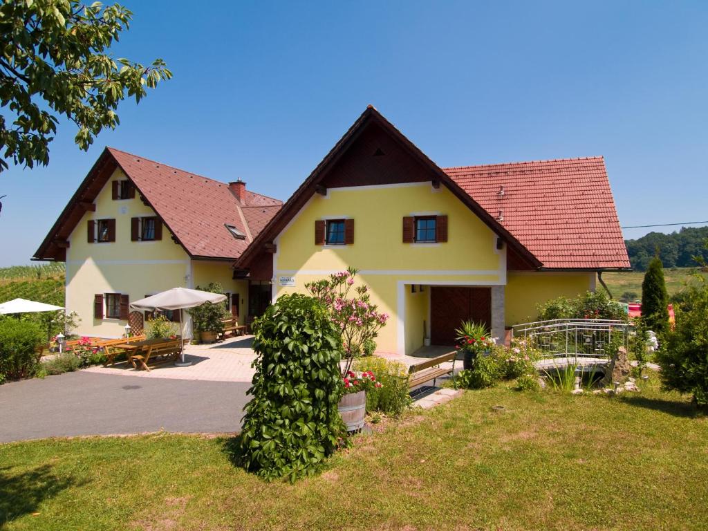 韦因地区拉奇Weingut Schwarzl的红色屋顶的大型黄色房屋
