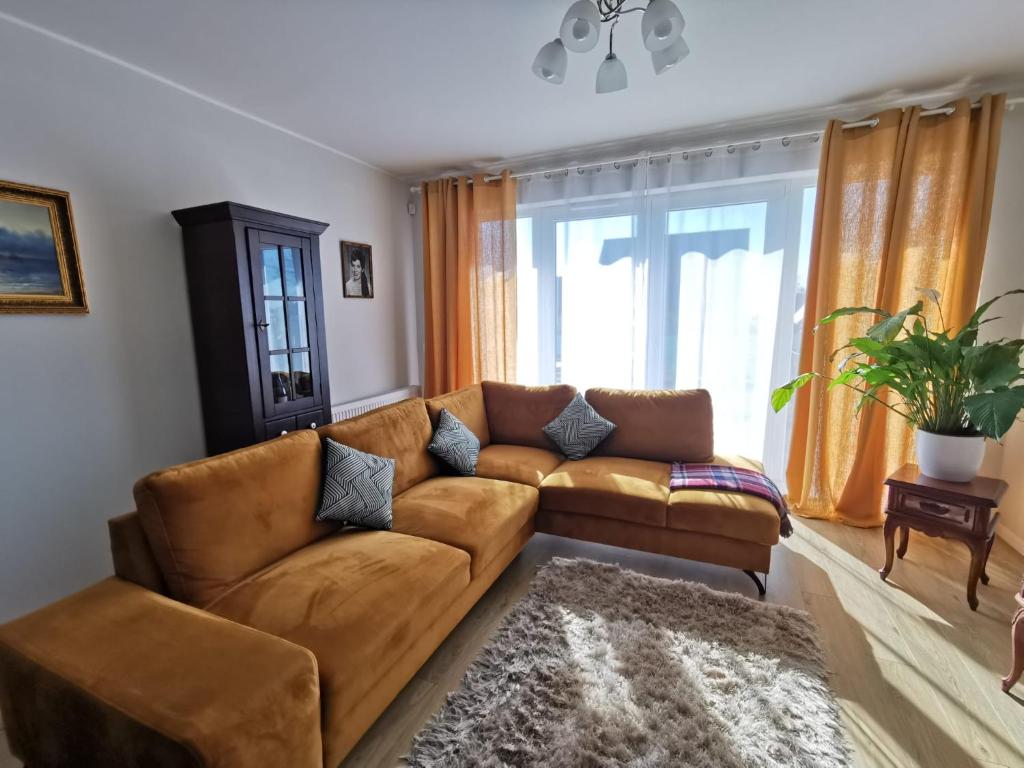 瓦古夫Milusi Domek的客厅设有棕色的沙发和窗户。