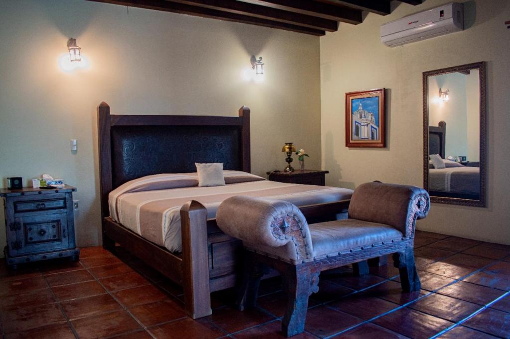 科利马戈韦尔纳多尔牧场精品酒店的一间卧室配有一张床、一把椅子和镜子