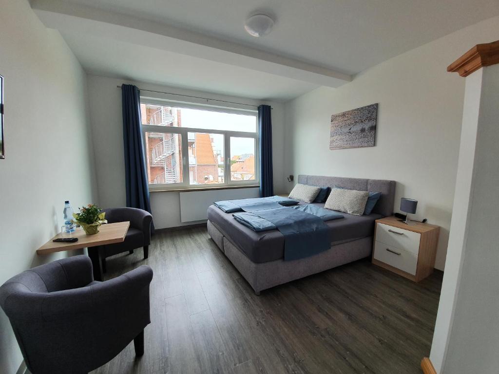 于斯德Inselkern Einraum-Apartments的卧室配有床、椅子和窗户。