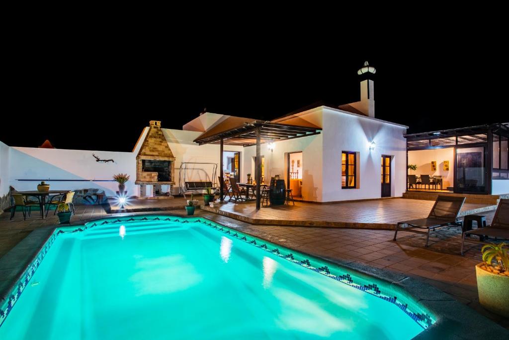 GüimeEslanzarote Acoruma House, Super Wifi, Heated Pool的夜间在房子前面的游泳池