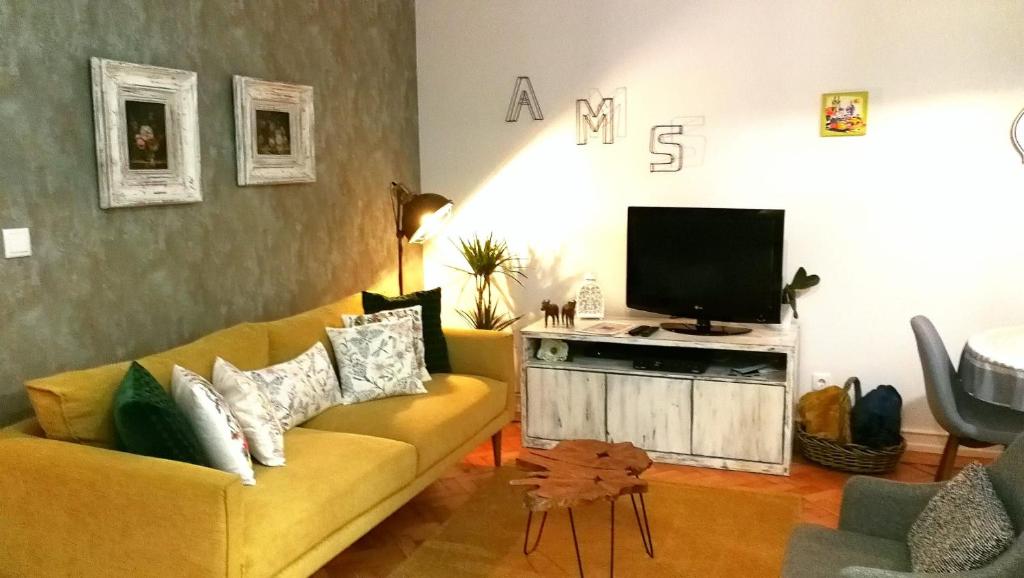 里斯本The sunset Lisbon flat的客厅配有黄色沙发和电视