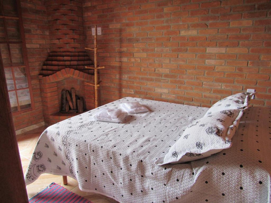 康塞高伊比蒂波卡CHALÉ Nativo R do Céu nº 106的砖墙房间的一个床位