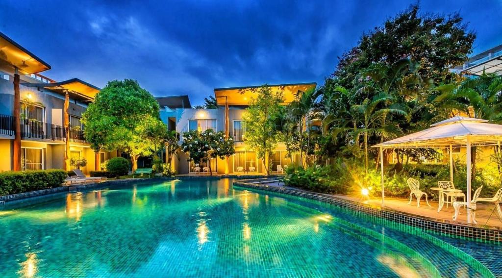 邦波Paeva Luxury Serviced Residence SHA的一座带遮阳伞的房屋前的游泳池