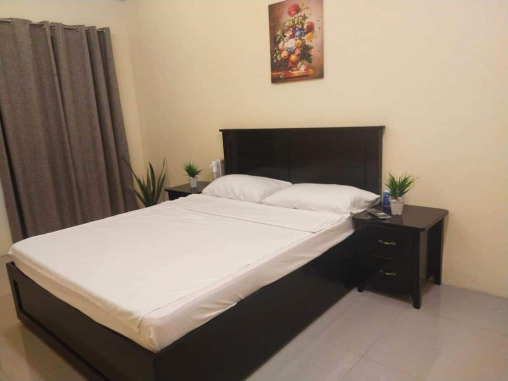 San JuanRedDoorz @ KBL Transient Inn San Fernando的一间卧室配有一张大床和黑色床头板