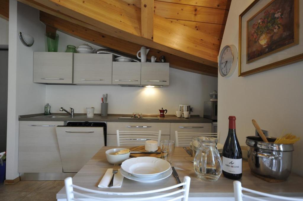 科马诺泰梅APPARTAMENTO MONTE - VALANDRO-的厨房配有带白色橱柜的木桌