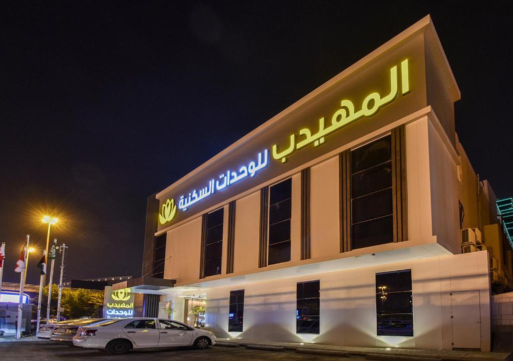 利雅德Al Muhaidb Al Mohammadiyyah - Riyadh的夜间停在大楼前的汽车