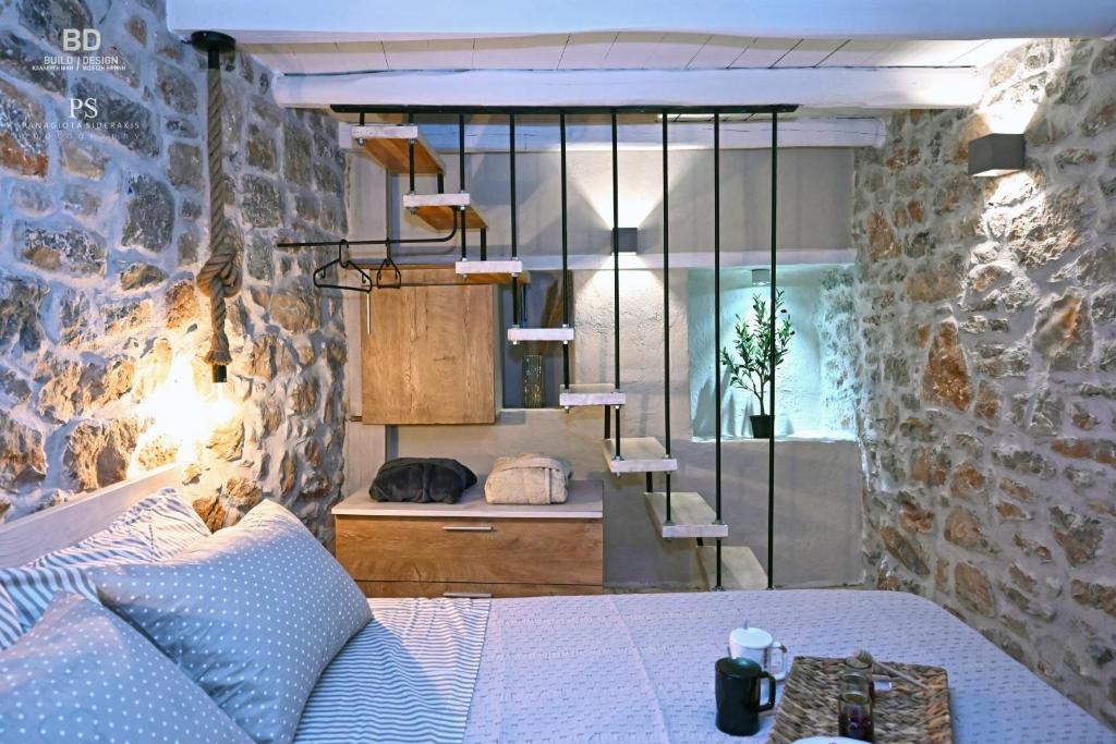 Avgonyma皮尔戈斯餐厅公寓的一间卧室设有一张床和石墙