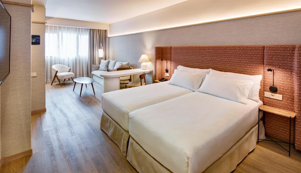 波苏埃洛-德阿拉尔孔Sercotel Pozuelo的酒店客房设有一张大床和一张书桌。