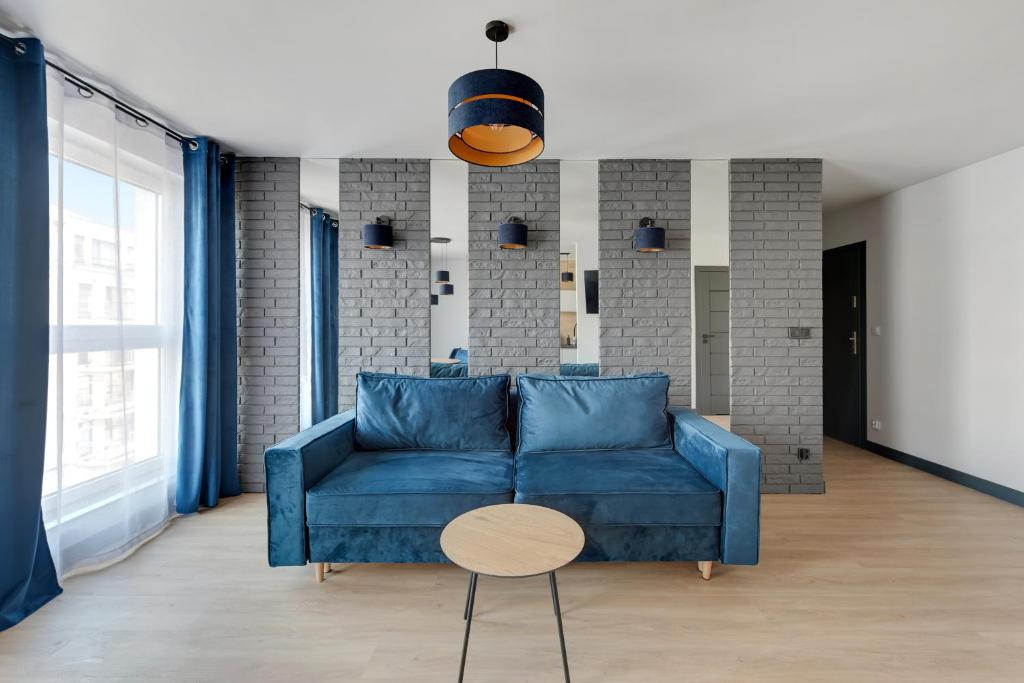 格但斯克Angielska Grobla 5 Apartinfo Apartments的客厅配有蓝色的沙发和桌子