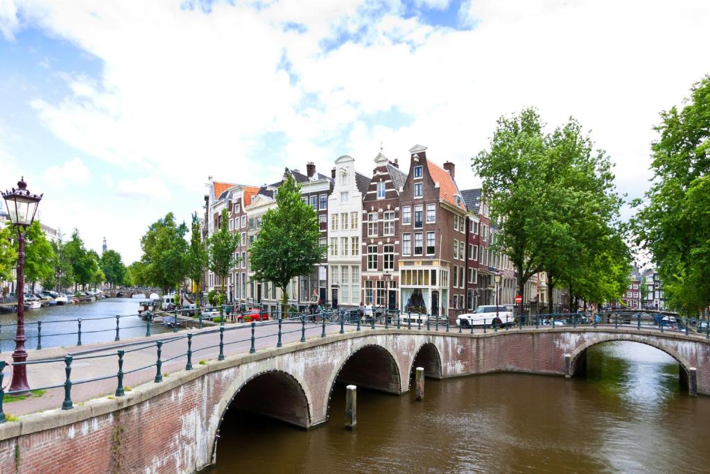 阿姆斯特丹Crown Hotel的一座建有建筑物的城市里河流上的桥梁