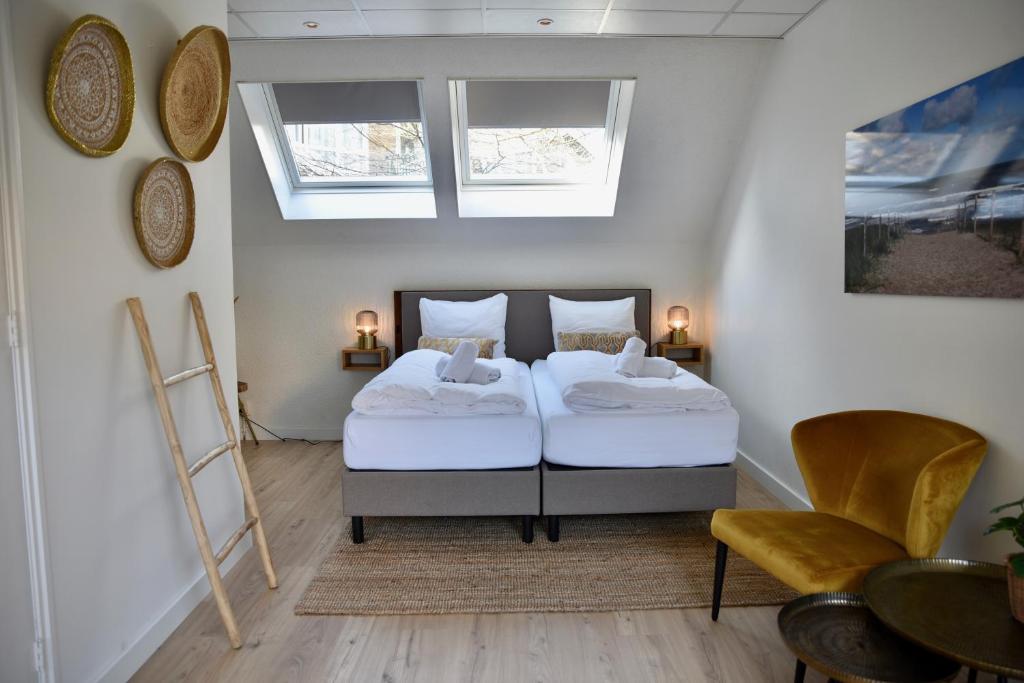 赞德沃特霍夫范玛斯酒店的一间卧室配有两张床和一张桌子及椅子