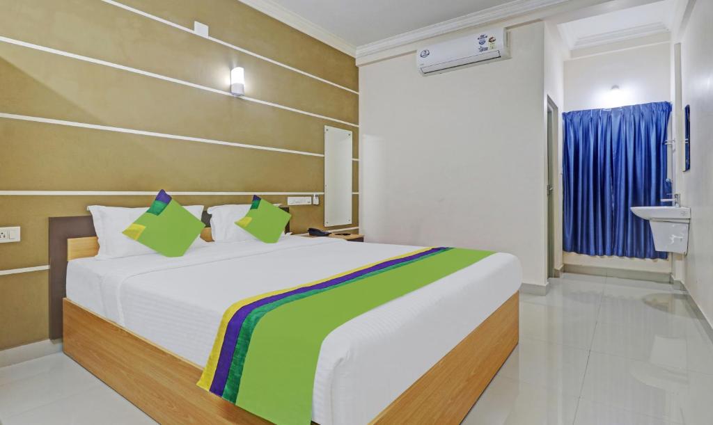 尼杜巴塞莱Treebo Trend Thoduvas Star Plaza Cochin Airport的一间卧室配有一张床和一个水槽