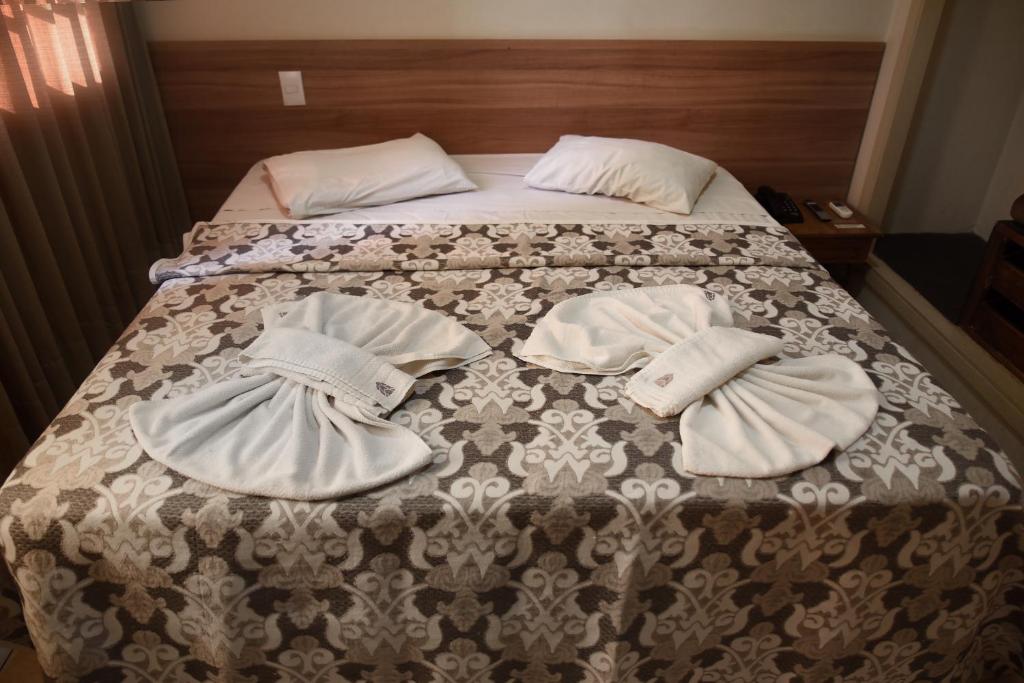 普雷图河畔圣若泽伊塔马拉蒂酒店的一张带两顶帽子和毛巾的床