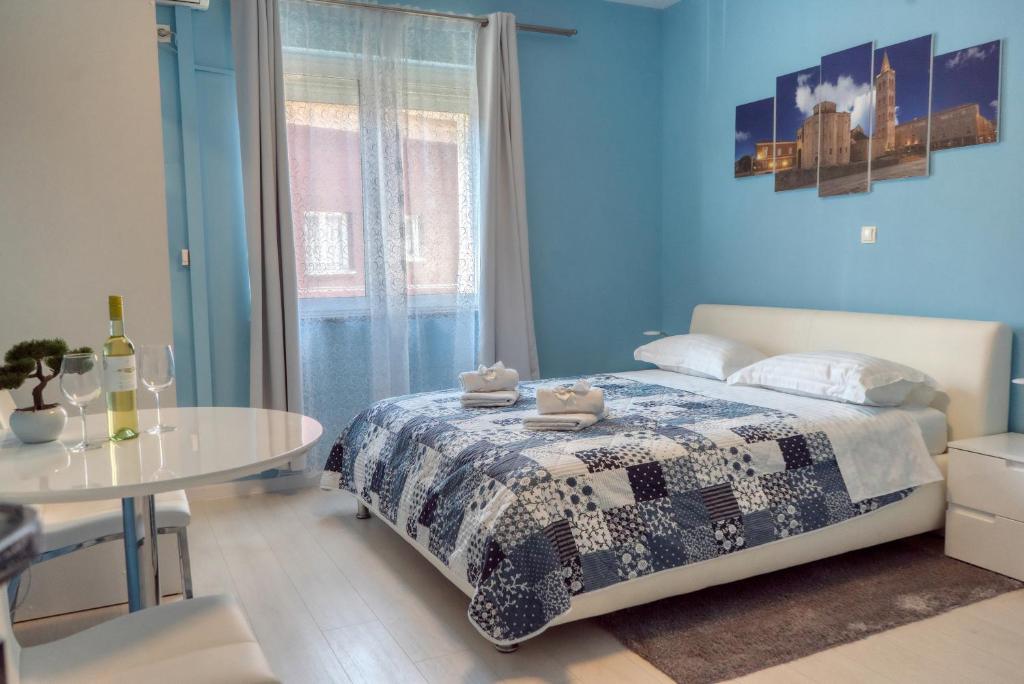 扎达尔Apartments & Rooms Andrea 2的蓝色卧室,配有床和桌子