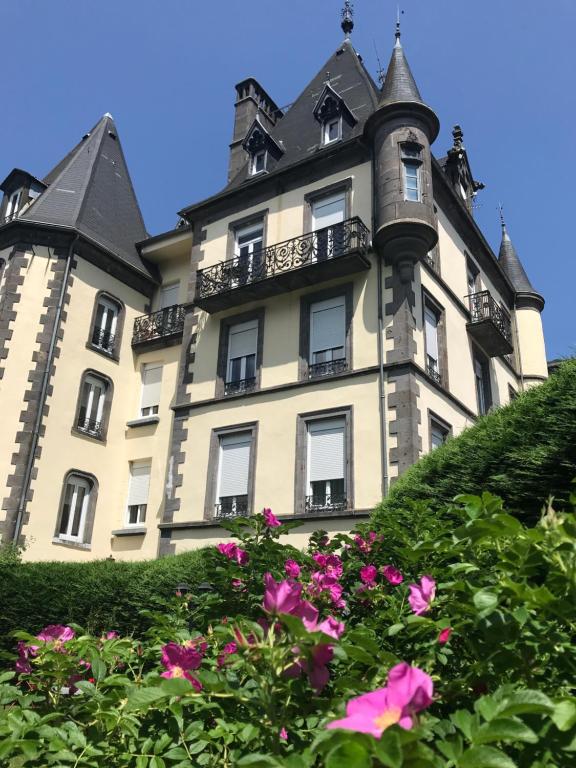 勒蒙多尔Le Grand Hôtel Mont Dore的一座大型建筑,前面有窗户和鲜花