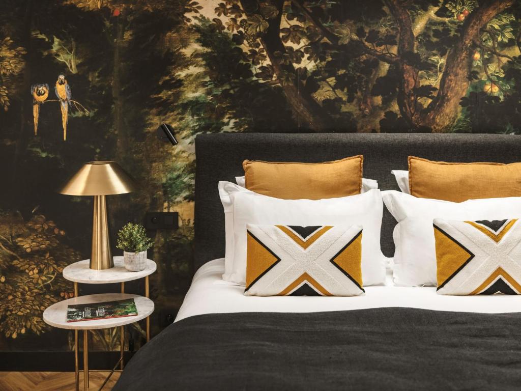 马赛Maisons du Monde Hôtel &amp; Suites - Marseille Vieux Port的卧室里有一张床，上面有枕头和一幅画