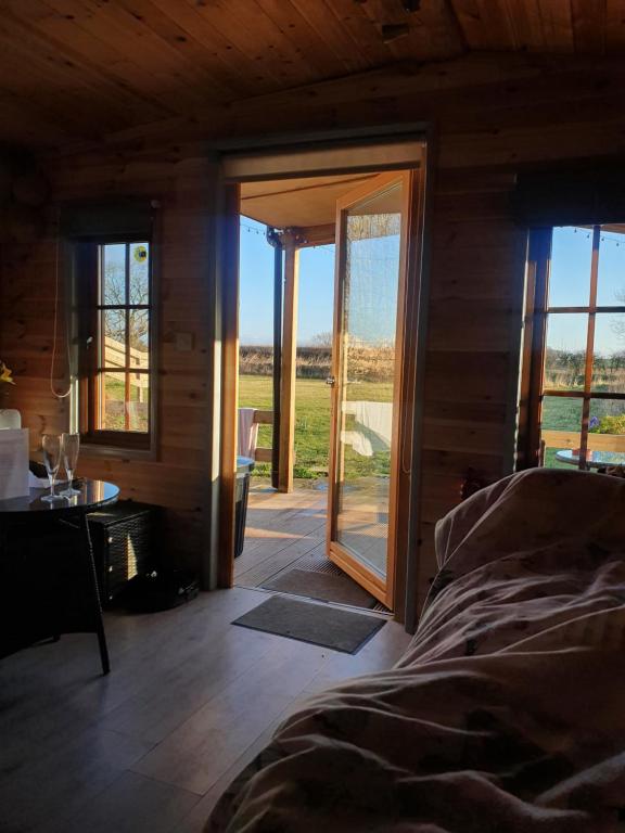 TuxfordBeautiful Wooden tiny house, Glamping cabin with hot tub 2的一间卧室设有一张床和一个滑动玻璃门