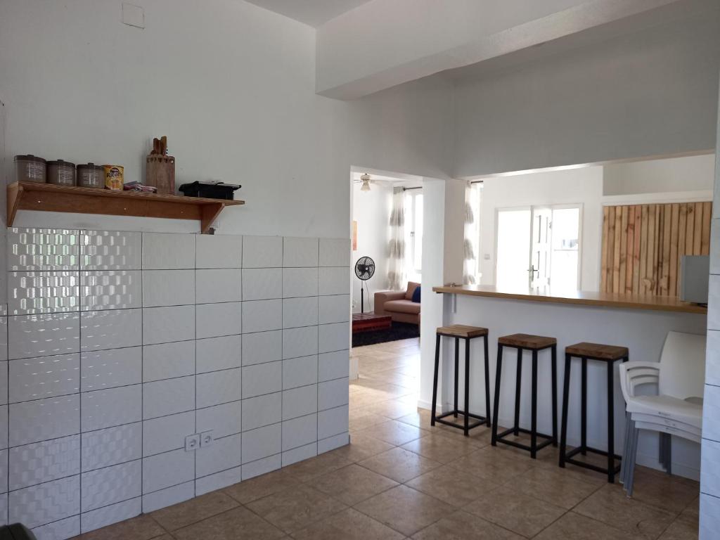 蓬塔杜欧鲁Casa Cinza的一间厨房,内配白色瓷砖和凳子
