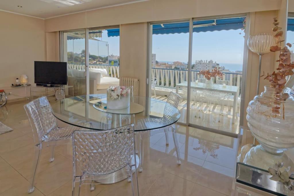 戛纳CANNES Vue Mer的一间用餐室,配有玻璃桌和蛋糕