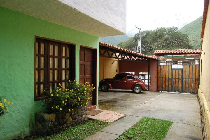 MéridaCabañas Falconia的停在绿色房子旁边的车库里的汽车