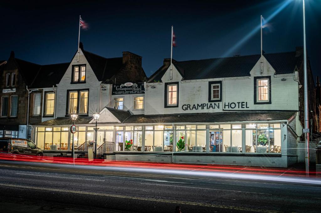 珀斯Grampian Hotel的一座建筑,在晚上前方有标志