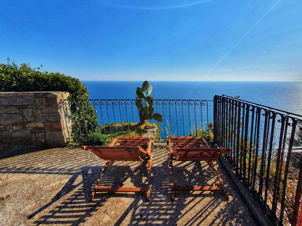 克里日亚La Terrazza Sul Blu的两把木椅位于一个俯瞰着大海的阳台