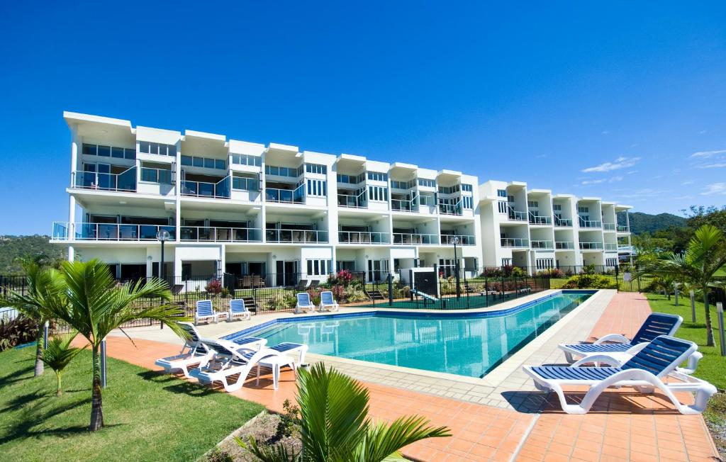 耐莉湾海滨磁力海港公寓式酒店的大型酒店,设有游泳池和躺椅
