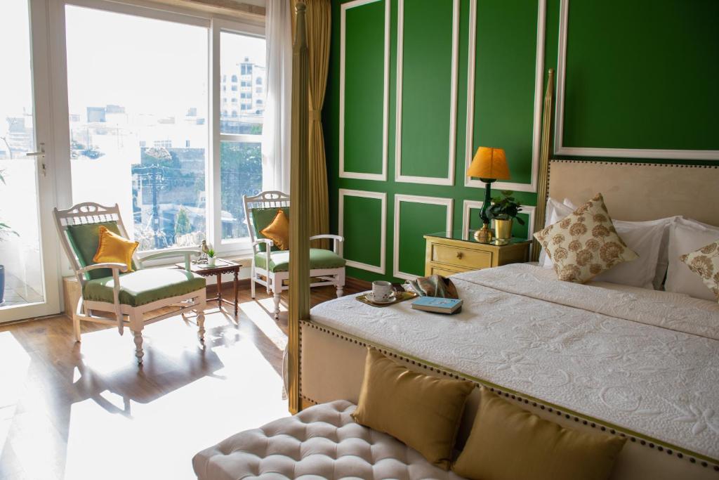 斋浦尔Dileep Kothi - A Royal Boutique Luxury Suites in Jaipur的一间卧室设有一张大床和绿色的墙壁