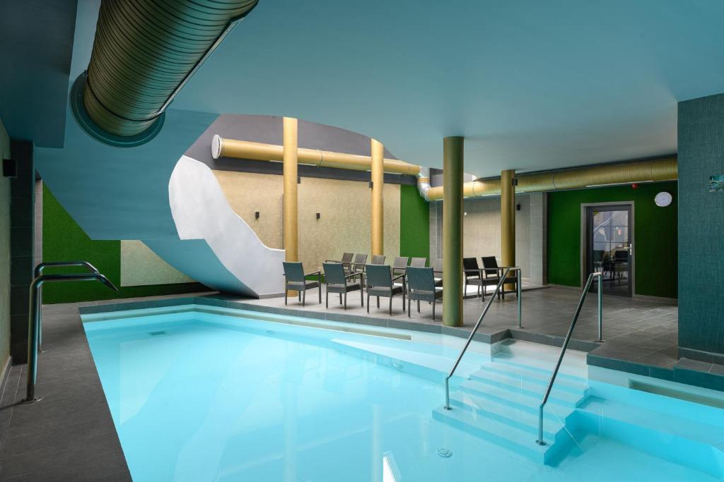 豪伊杜索博斯洛阿姆布罗子亚公园酒店的一个带椅子和桌子的大型游泳池