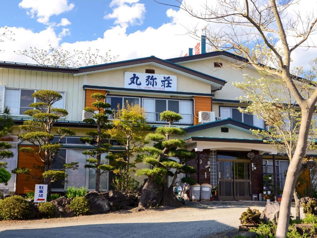 富士河口湖丸弥庄酒店的前面有棵树的建筑