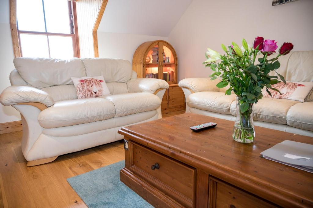 勒威克Fort Charlotte的客厅配有两张沙发和一束鲜花