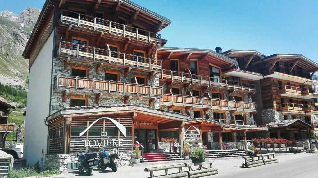 瓦勒迪泽尔Hotel La Toviere的前面有长椅的大型木制建筑