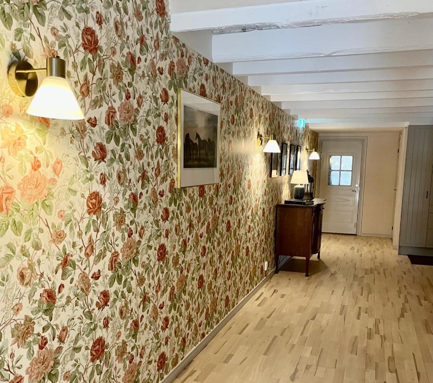 恩雪平Rekasta Bed & Breakfast的一间设有花卉墙纸和走廊的房间