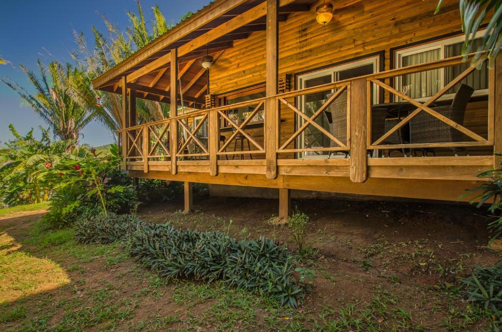 罗阿坦Relaxing Tropical Cabin的一间木房子,旁边设有门廊