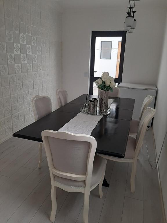 开普敦White house的一张黑色餐桌,配有白色椅子和镜子
