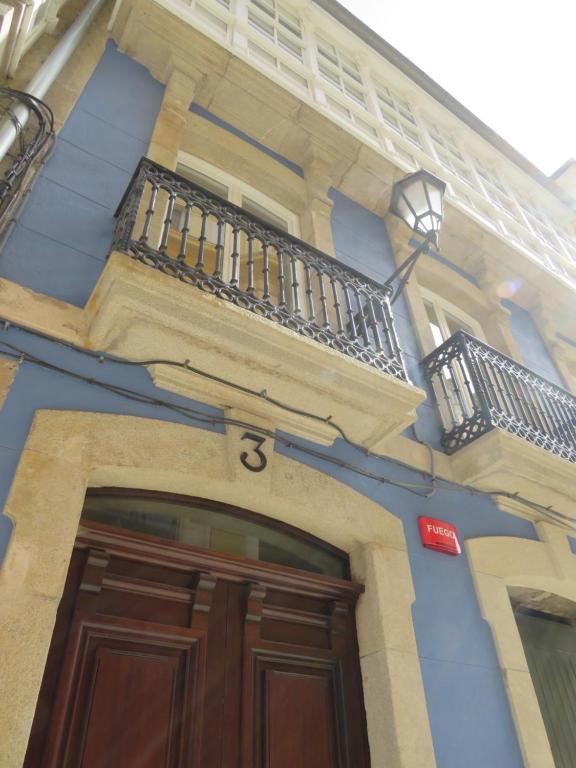 卢戈APARTAMENTOS ARMANYA 3的蓝色的建筑,设有木门和阳台