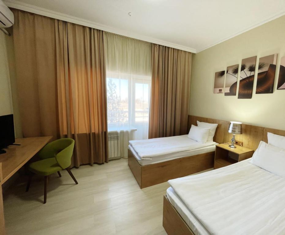 阿克套Aktau Airport Hotel的酒店客房配有两张床和一张书桌