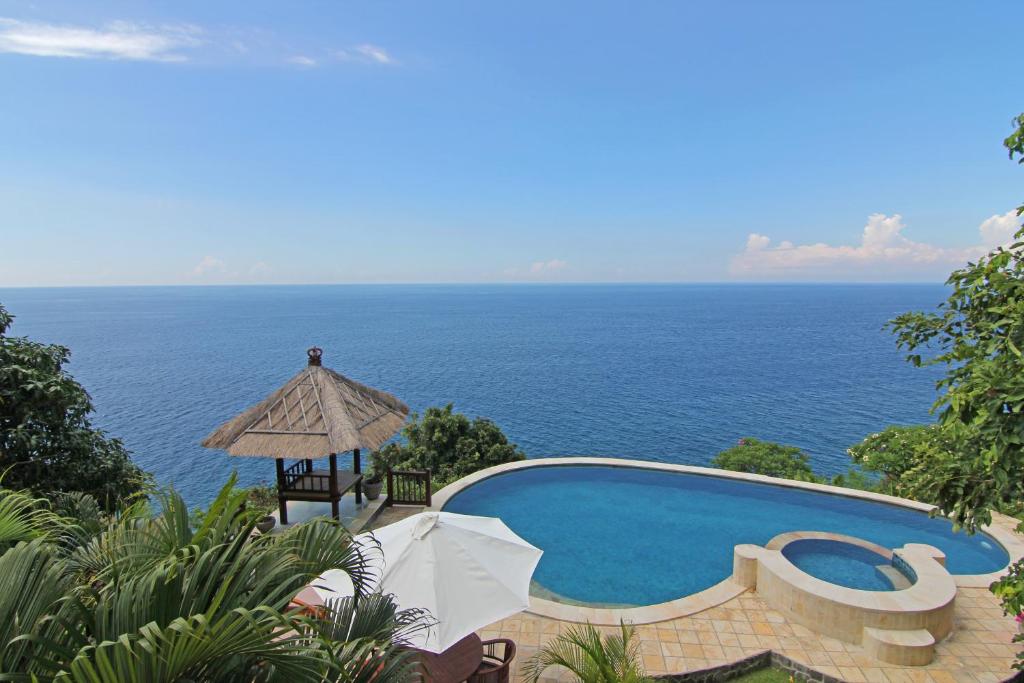 艾湄湾峇都汤加别墅酒店的一座背景海洋的游泳池